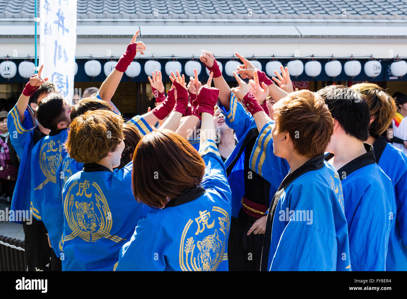 Junge erwachsene Japaner Dance Troupe in blaue yukata Jacken, versammelt und hohe Fiving, Gambatte, bevor es auf der Bühne für Yosakoi Dance Nummer. Stockfoto