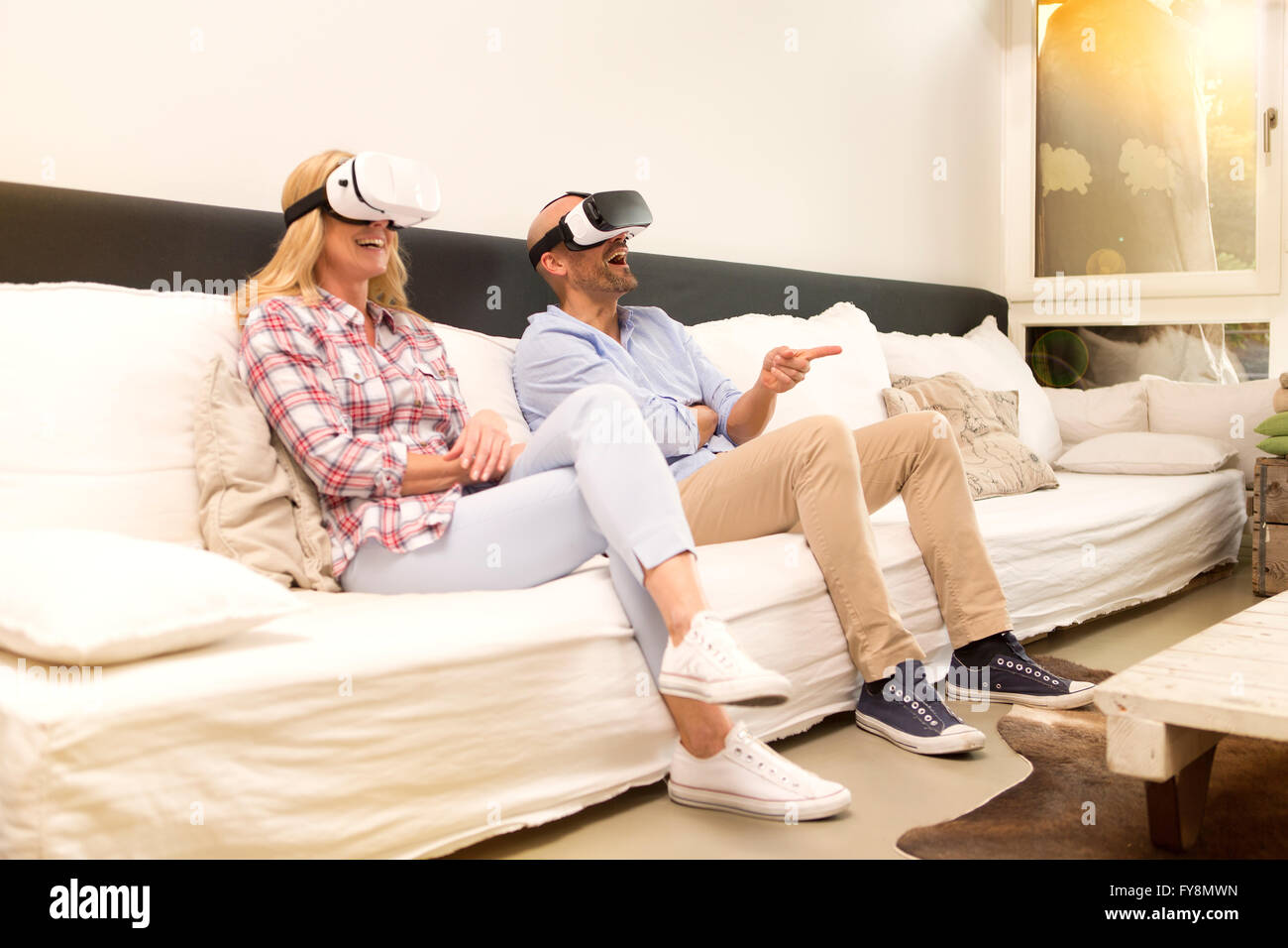 Einige sitzen auf der Couch zu Hause mittels Virtual-Reality-Brille Stockfoto