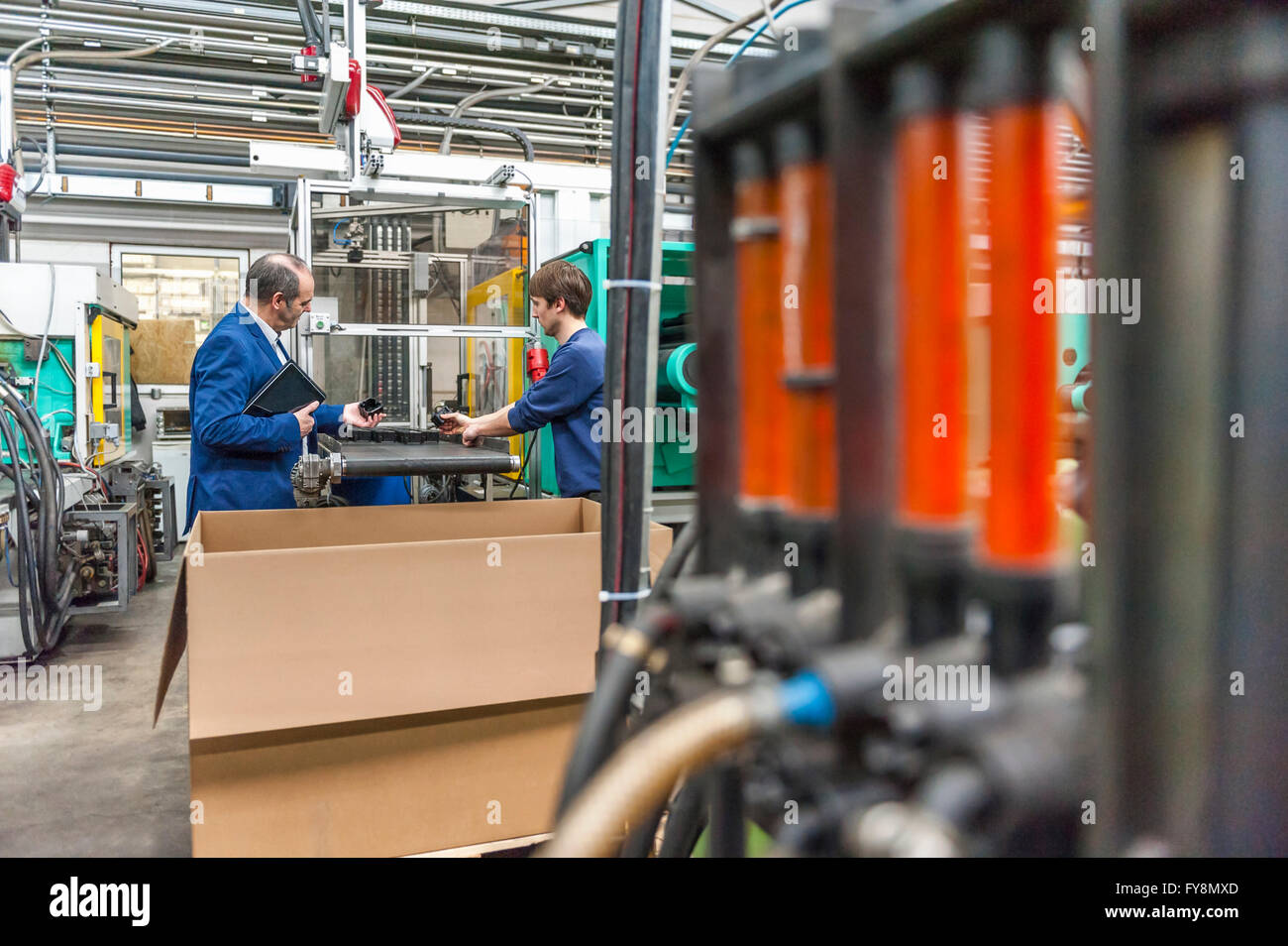 Manager und Arbeiter mit Arbeitstreffen in Kunststoff-Fabrik Stockfoto