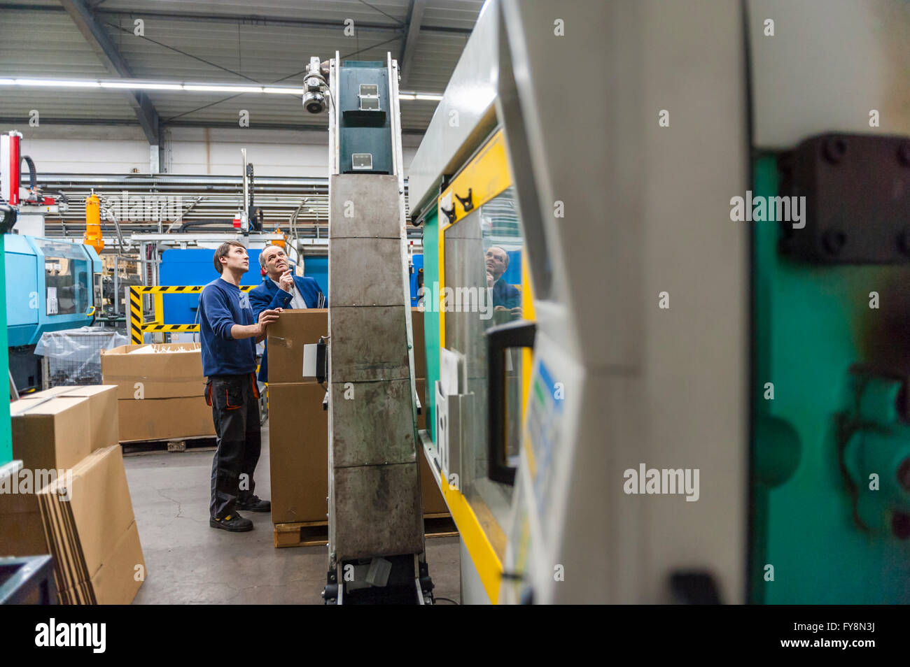 Zwei Personen in Kunststoff Fabrik Prüfung Maschinen Stockfoto