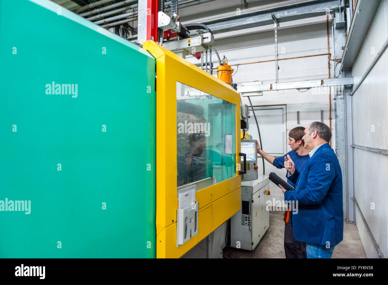 Manager und Arbeiter in Kunststoff Fabrik diskutieren Produktionsqualität Stockfoto