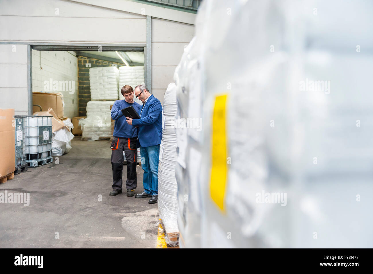 Manager und Arbeiter im Lager Kunststoff Fabrik prüfen Produkte Stockfoto