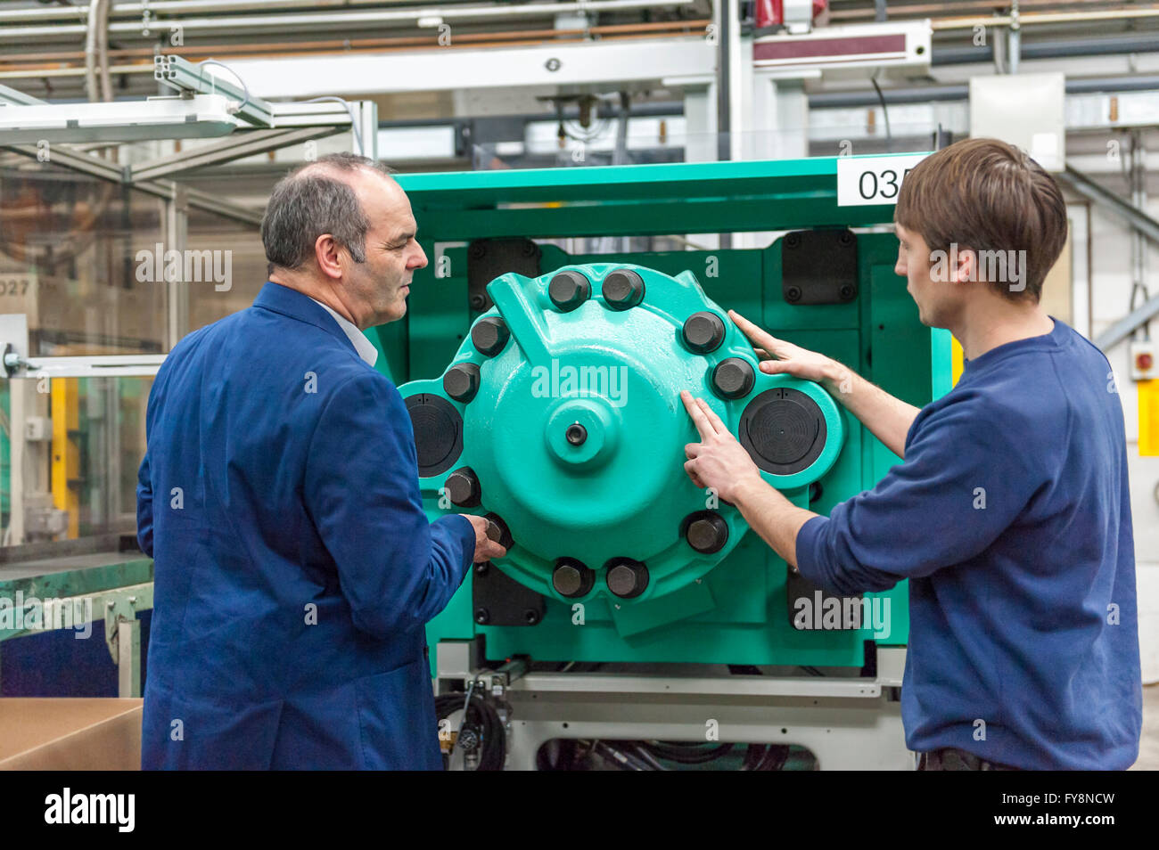 Zwei Personen in Kunststoff Fabrik Prüfung Maschinen Stockfoto