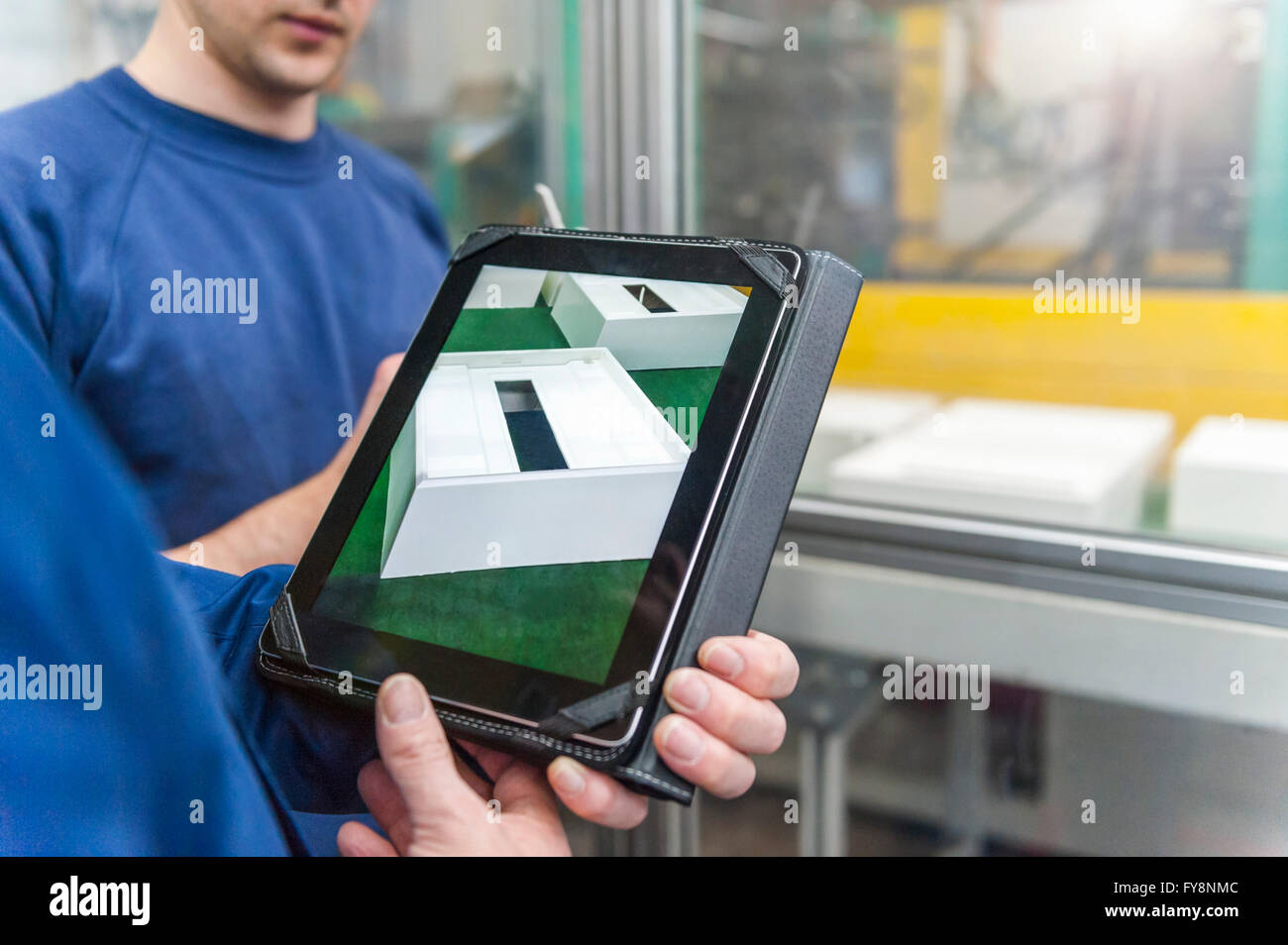 Manager und Arbeitnehmer tun Qualitätsbeurteilung in Kunststoff-Fabrik Stockfoto