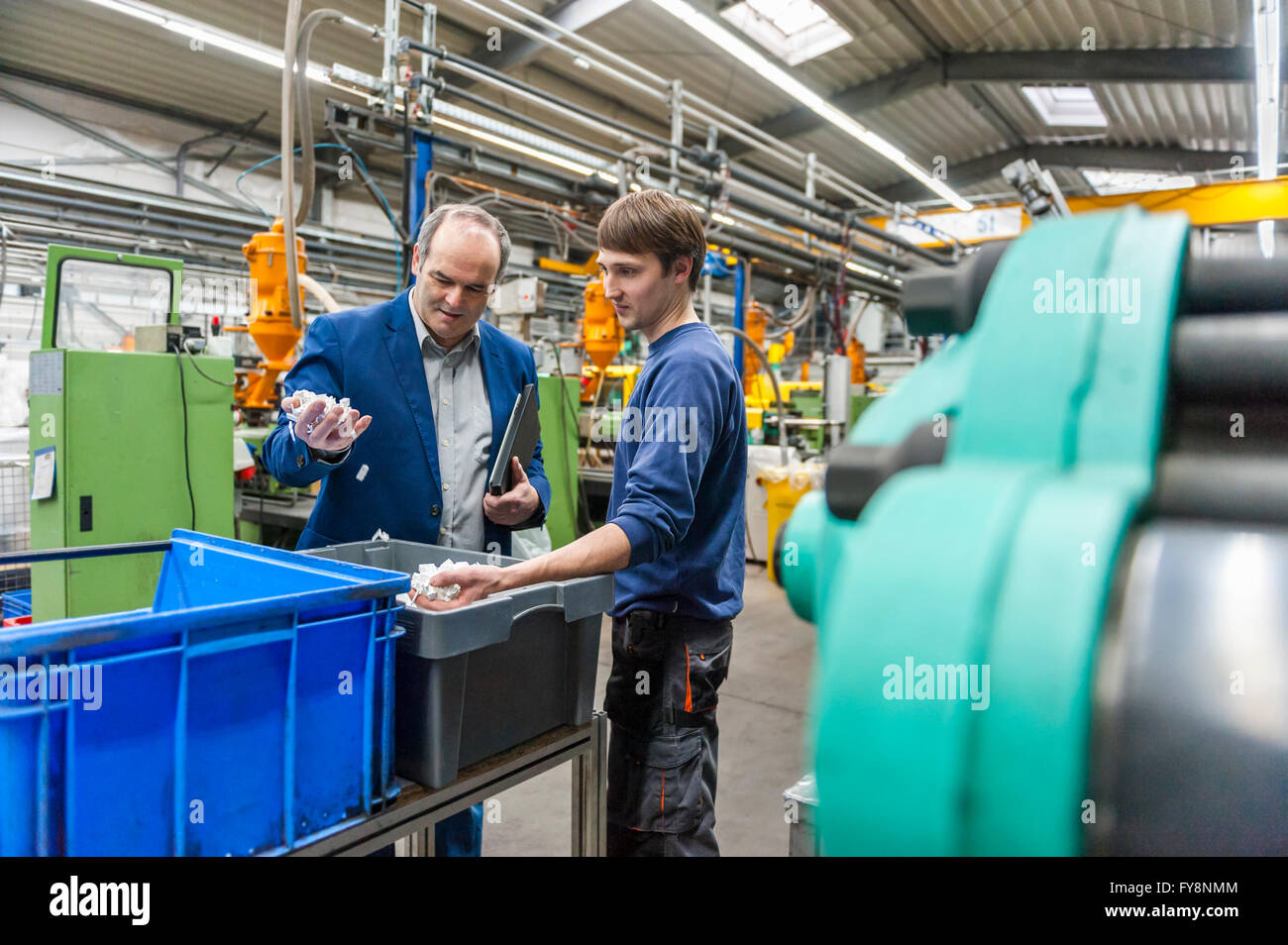 Manager und Arbeiter, die Prüfung der Produkte in Plastcs Fabrik Stockfoto