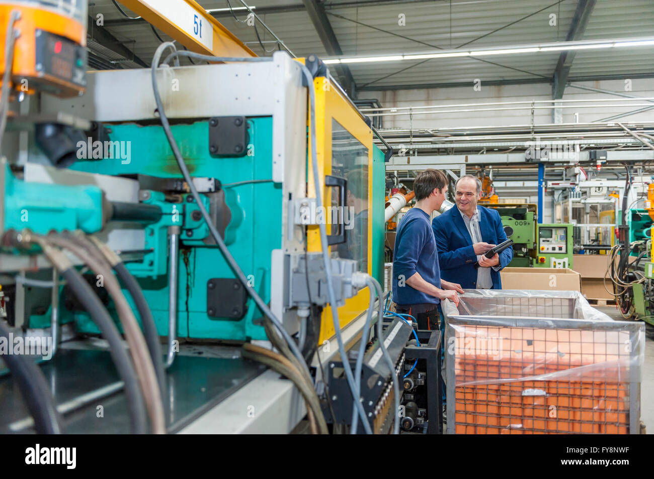 Manager und Arbeiter, die Prüfung von Kunststoff-Produkten im Werk Stockfoto