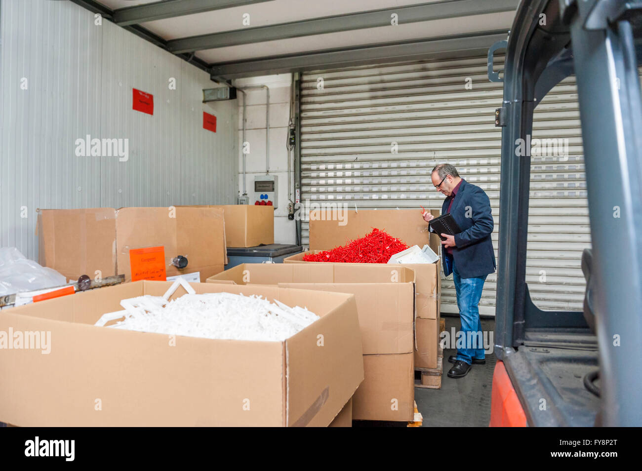 Manager bei Lagerung von Kunststoff-Fabrik prüfen Produkte Stockfoto