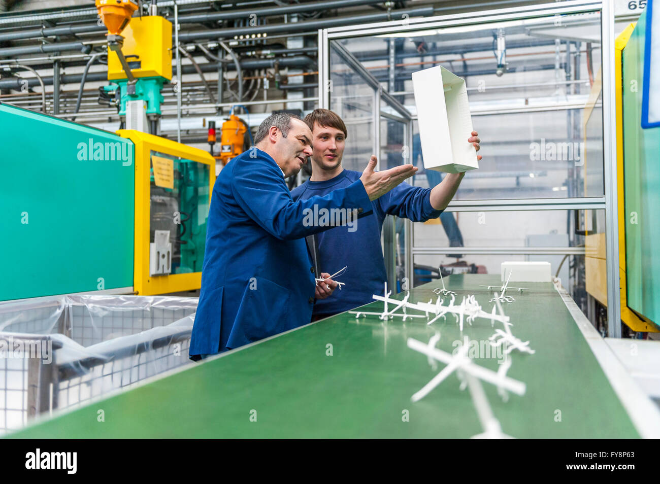 Manager und Arbeitnehmer tun Qualitätsbeurteilung in Kunststoff-Fabrik Stockfoto