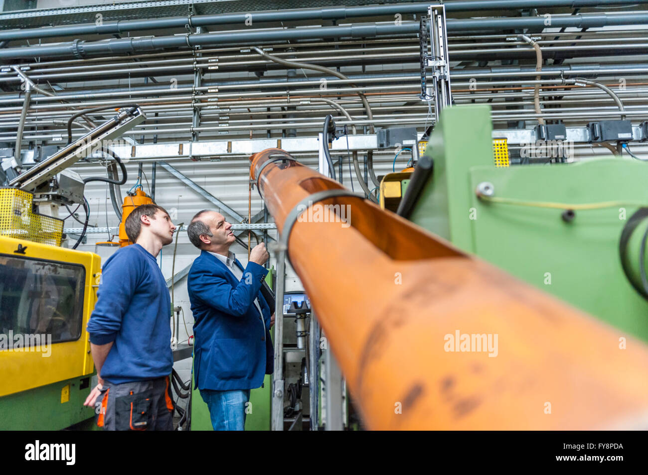 Zwei Personen in Kunststoff Fabrik Prüfung Maschinen Stockfoto