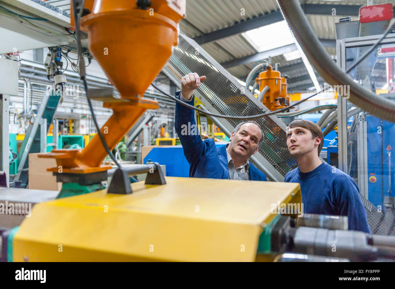 Zwei Personen in Kunststoff Fabrik Prüfung Maschinen Stockfoto