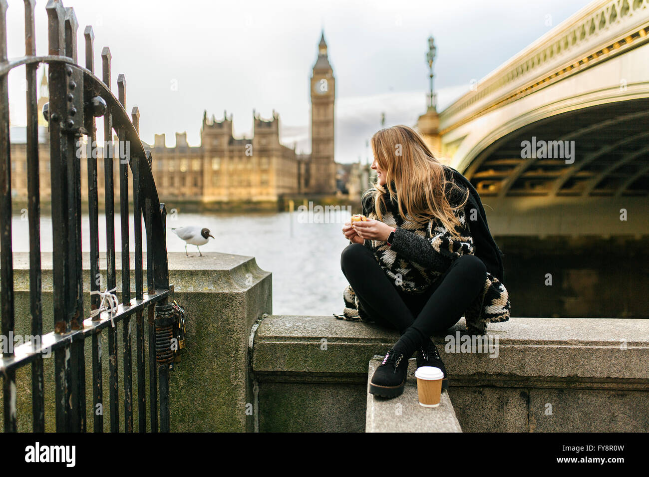 Großbritannien, London, junge Frau, die einen Snack in der Nähe von Westminster Bridge Stockfoto