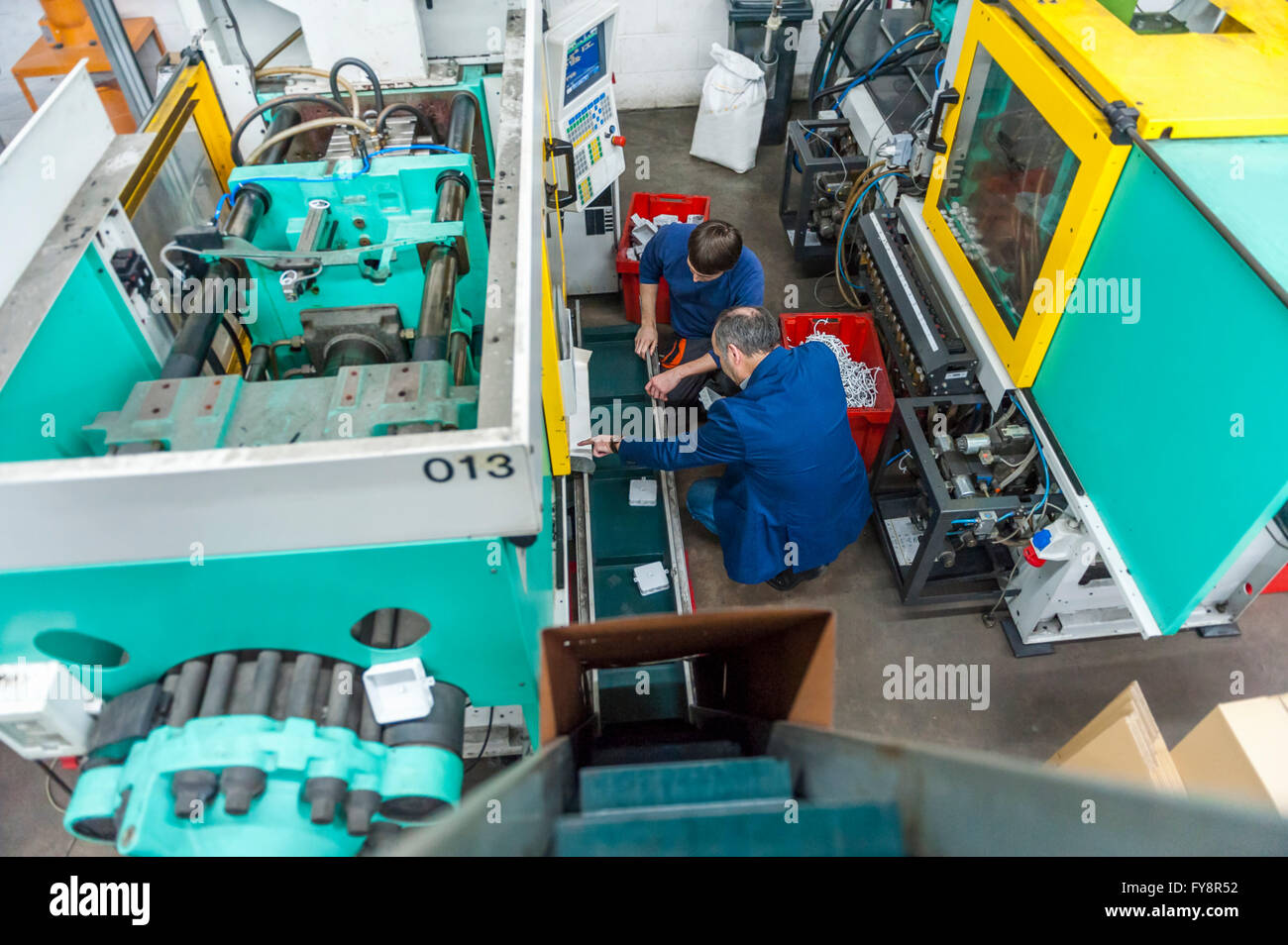 Zwei Personen in Kunststoff Fabrik Prüfung Maschinen Stockfoto