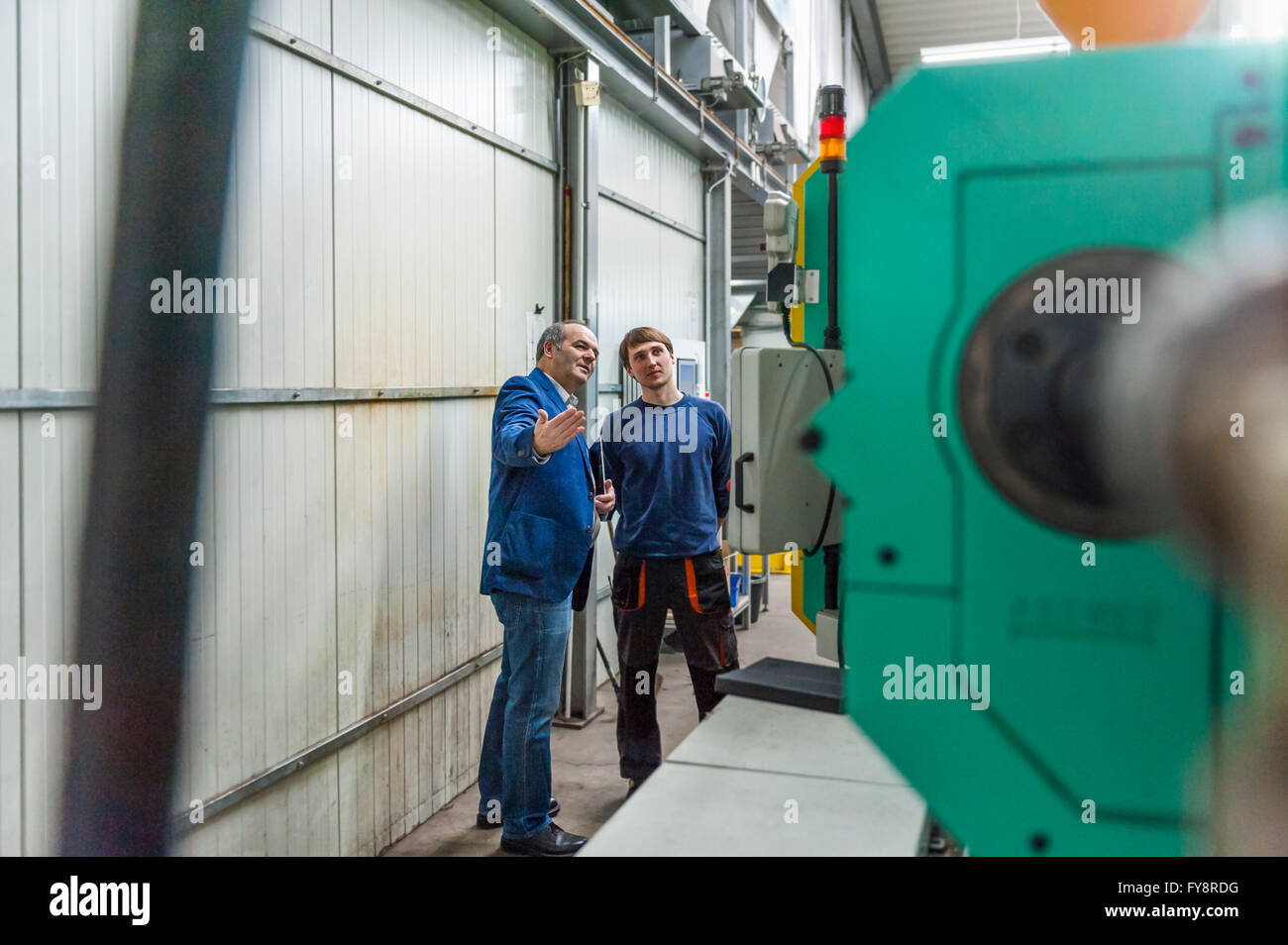 Manager und Arbeiter in Kunststoff Fabrik diskutieren Produktionsqualität Stockfoto