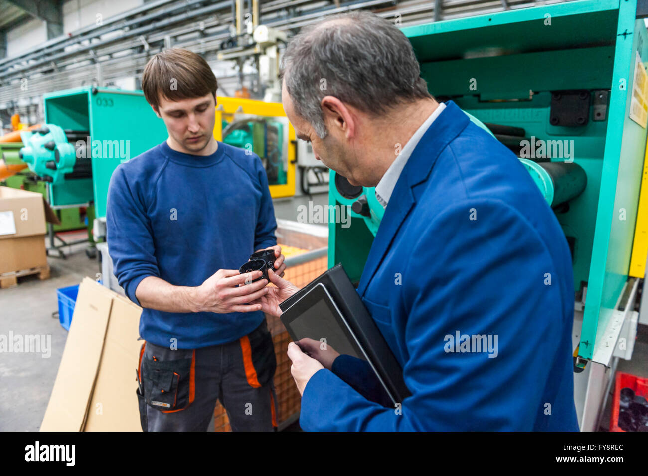 Manager und Arbeiter in Kunststoff Fabrik diskutieren Produktionsqualität Stockfoto
