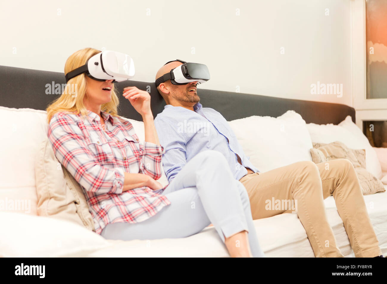 Einige sitzen auf der Couch zu Hause mittels Virtual-Reality-Brille Stockfoto