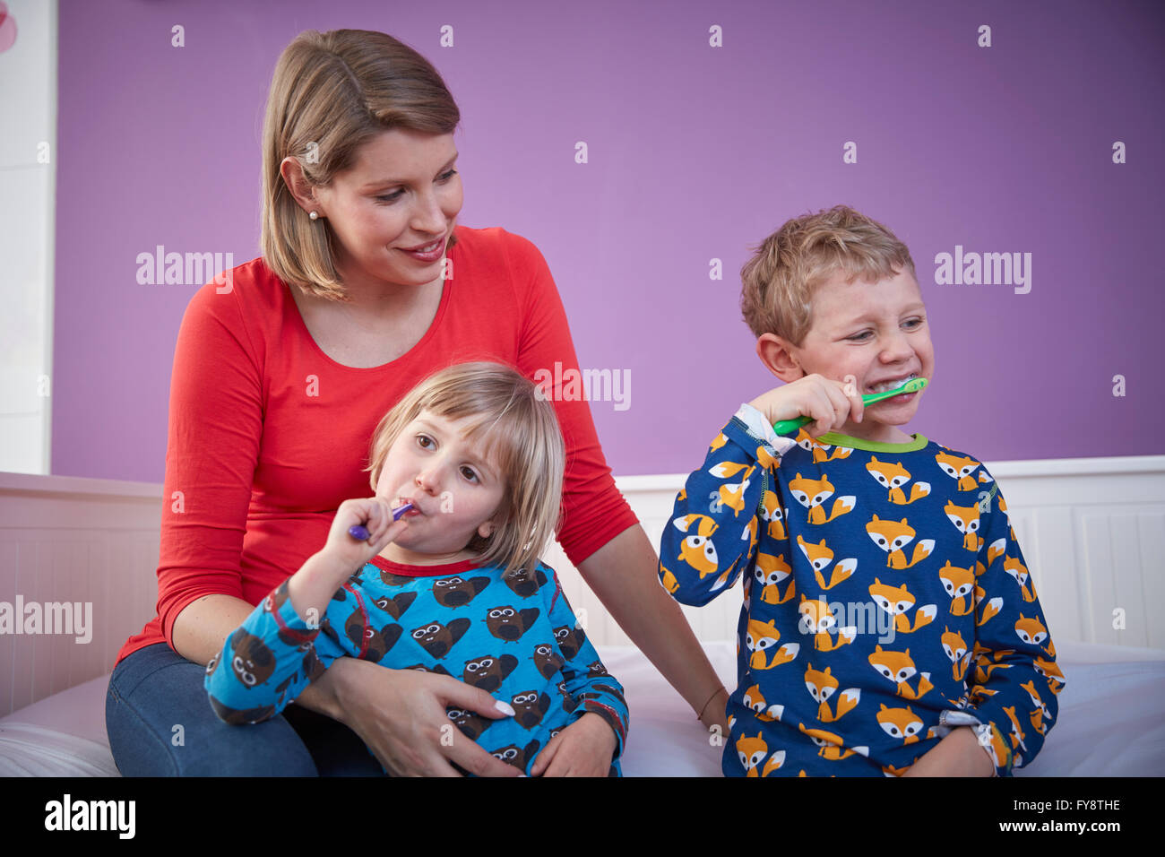 Mutter mit zwei Kindern, die Zähne zu putzen Stockfoto