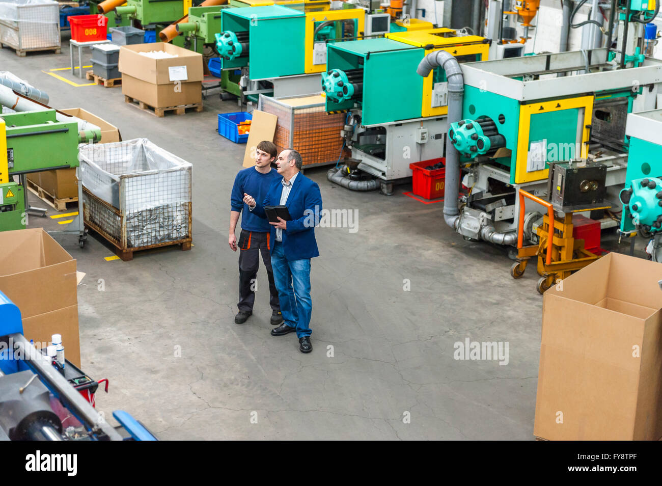 Manager und Arbeiter mit Arbeitstreffen in Kunststoff-Fabrik Stockfoto