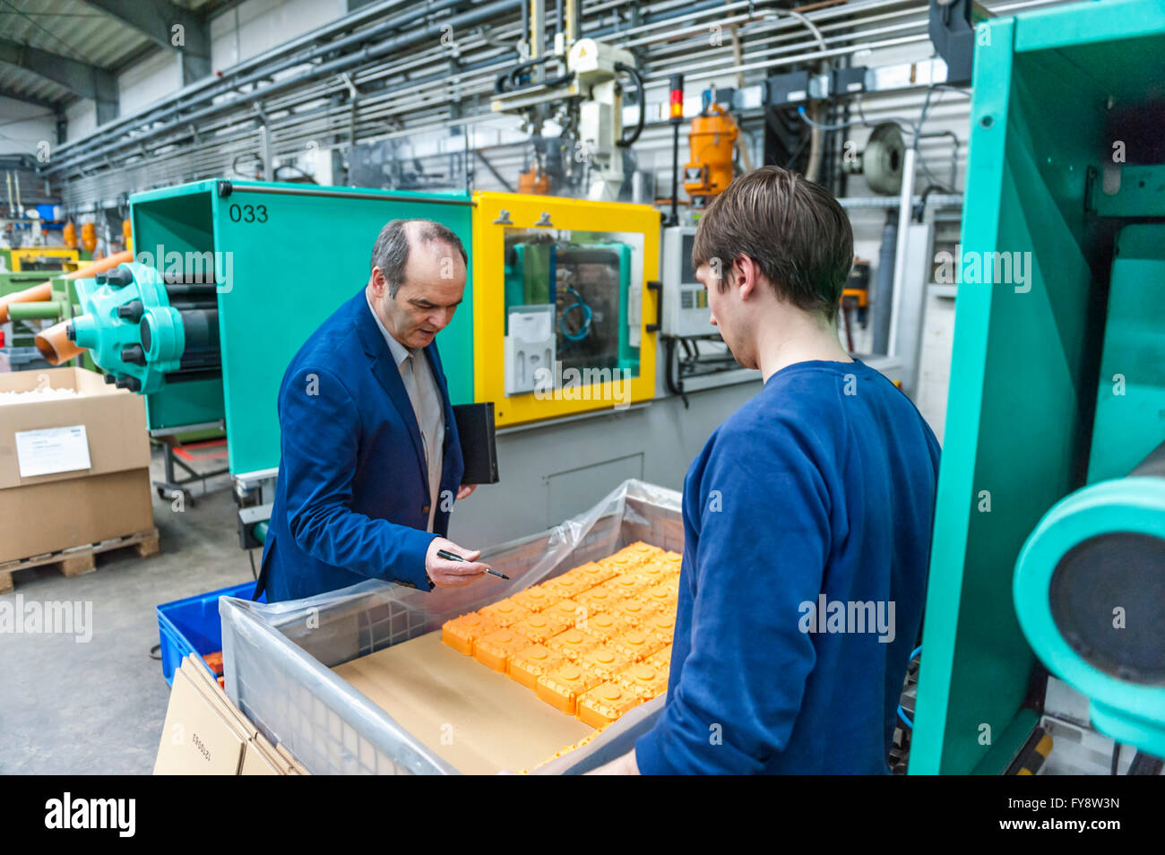 Manager und Arbeiter, die Prüfung von Kunststoff-Produkten im Werk Stockfoto