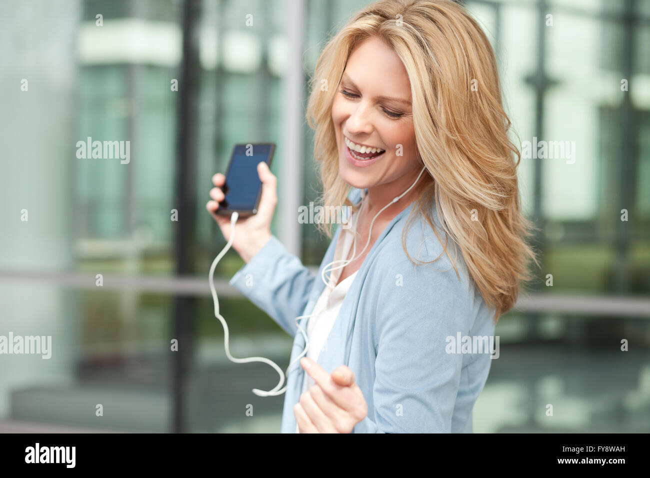 Glückliche Frau anhören von Musik vom smartphone Stockfoto