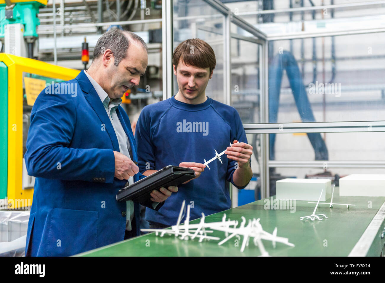 Manager und Arbeitnehmer tun Qualitätsbeurteilung in Kunststoff-Fabrik Stockfoto