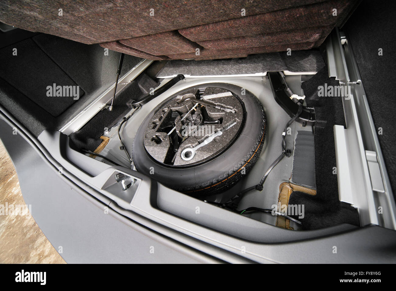 Reserverad im Kofferraum eines modernen Autos. Wagenheber anheben und Ersatzreifen  hinten im Fahrzeug Stockfotografie - Alamy