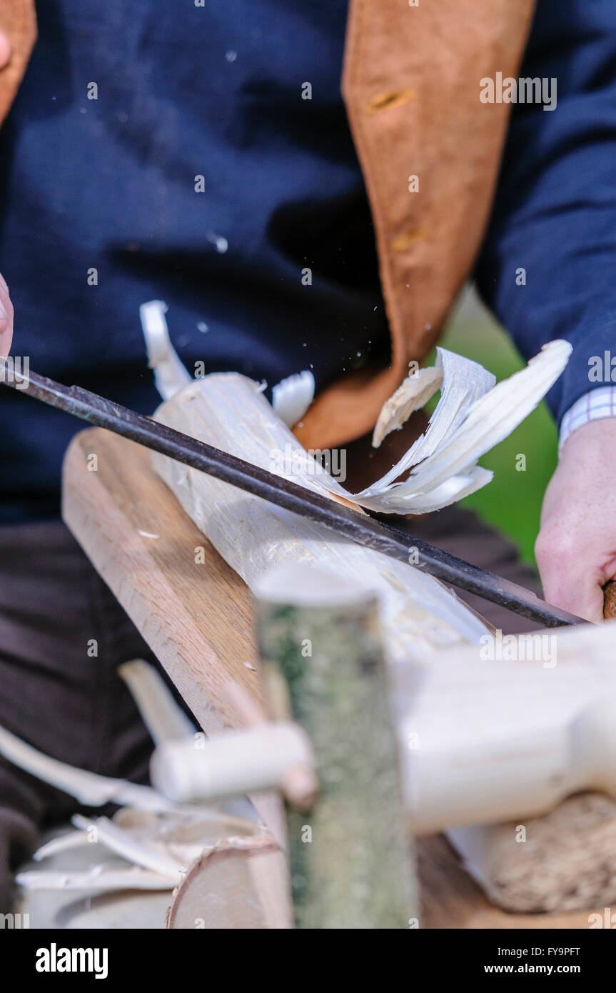 Holzbearbeitung Handwerker verwendet eine Schabhobel (Auslosung Flugzeug) um etwa ein Stück Holz Runde. Stockfoto