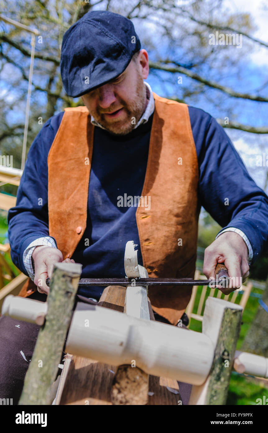 Holzbearbeitung Handwerker verwendet eine Schabhobel (Auslosung Flugzeug) um etwa ein Stück Holz Runde. Stockfoto