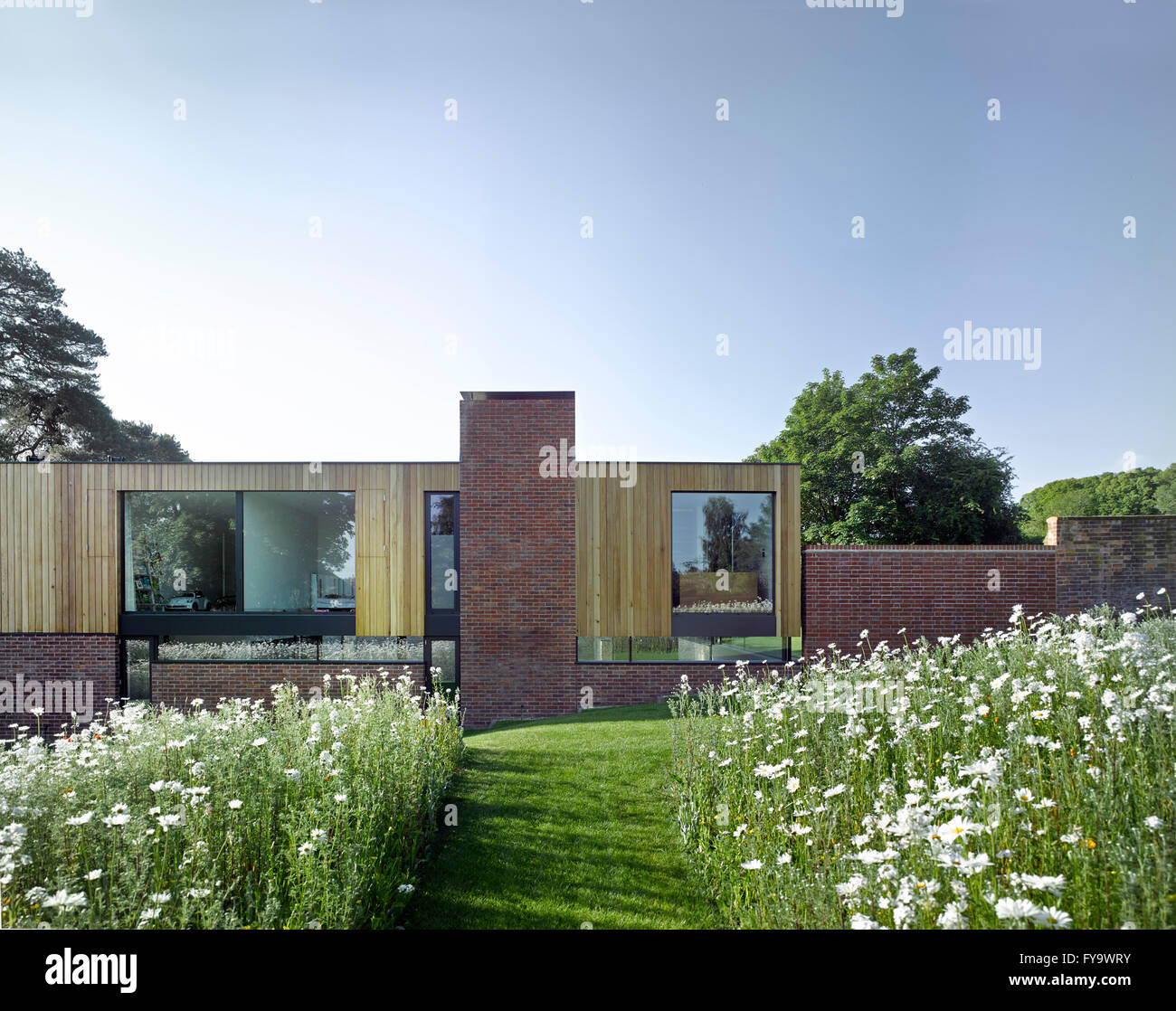Wiesenweg in Richtung Gebäude mit Gartenmauer. Cheeran Haus, Lower Basildon, Großbritannien. Architekt: John Pardey Architekten, 2015. Stockfoto