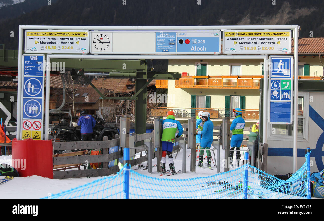 Mitglieder der italienischen Nationalmannschaft Ski Pass durch ein Tor auf einen Skilift eine Abfahrtspiste in Pozza Di Fassa, Italien Stockfoto