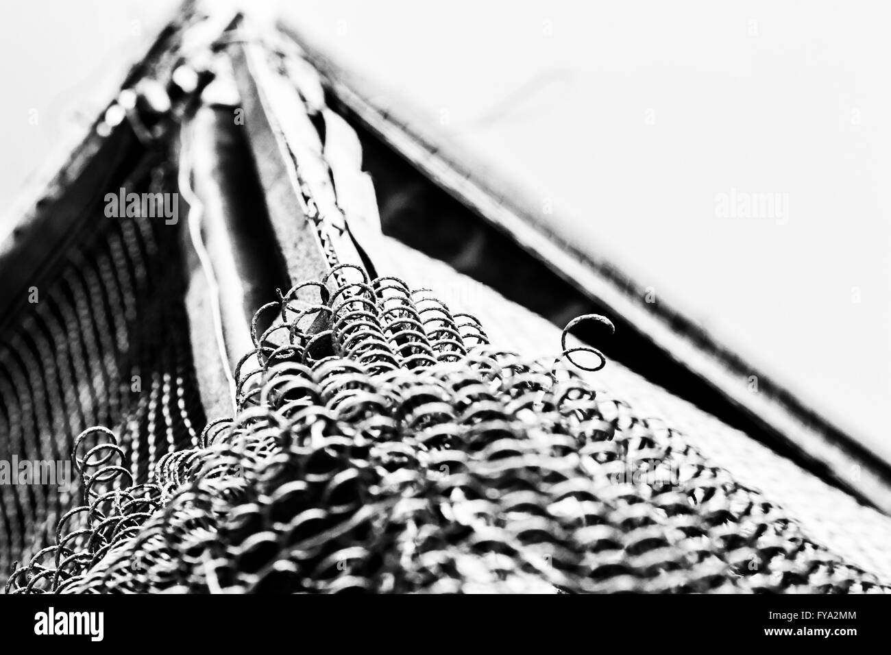 Gebrochen und Alter Draht Maschendrahtzaun in schwarz / weiß Monochrom Stockfoto