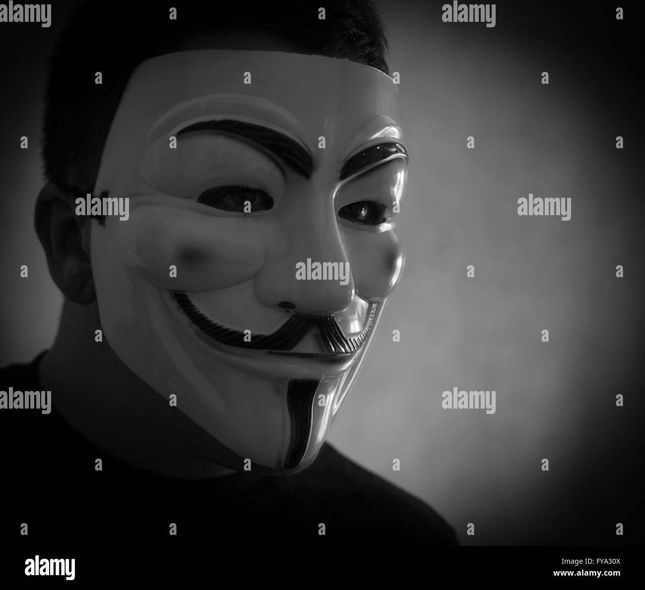 Mann trägt eine Guy Fawkes Maske beliebt bei Anonymität um seine Identität zu verschleiern Stockfoto