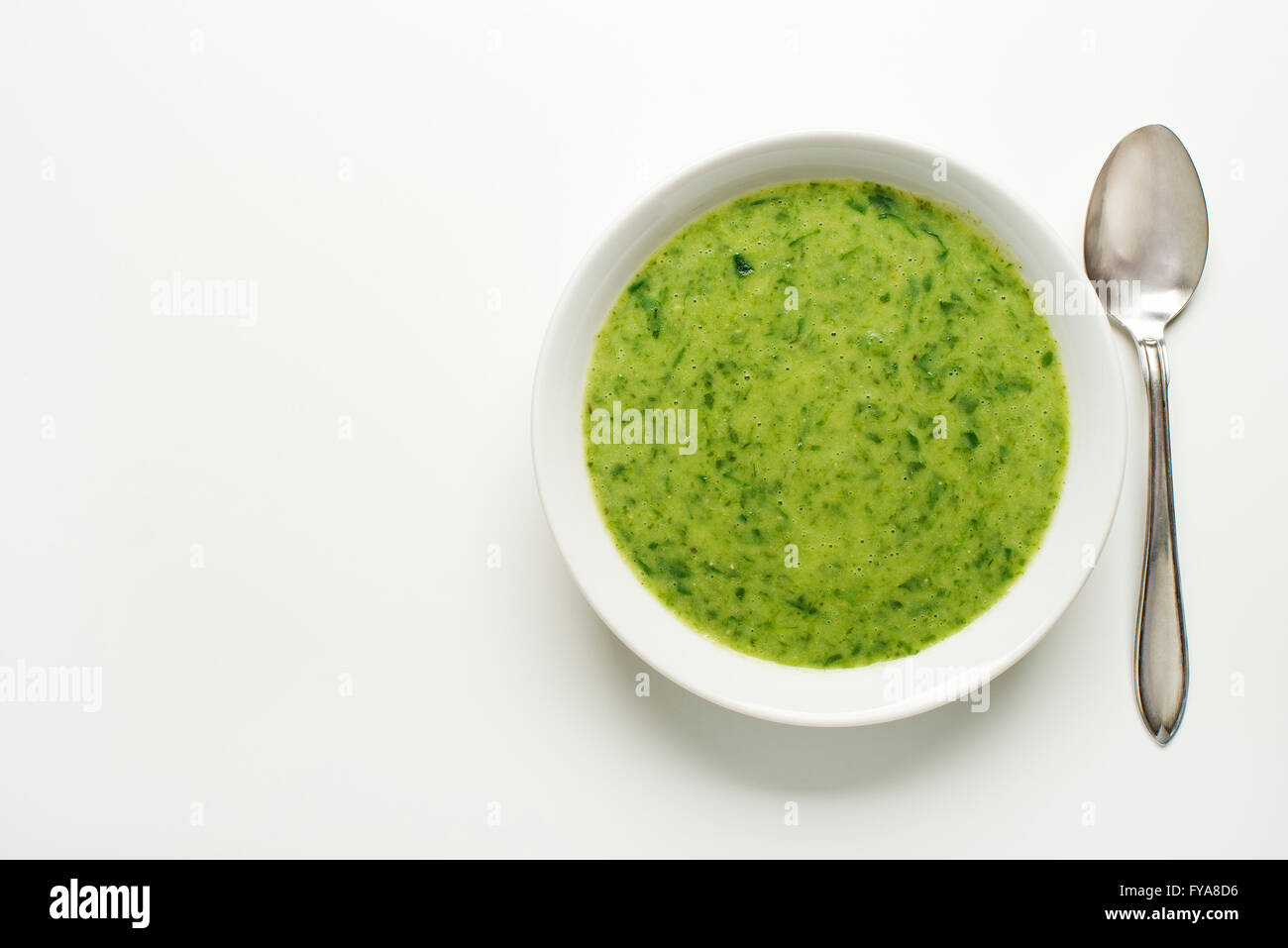 Frische grüne Suppe auf weißem Hintergrund Overhead schießen. Stockfoto