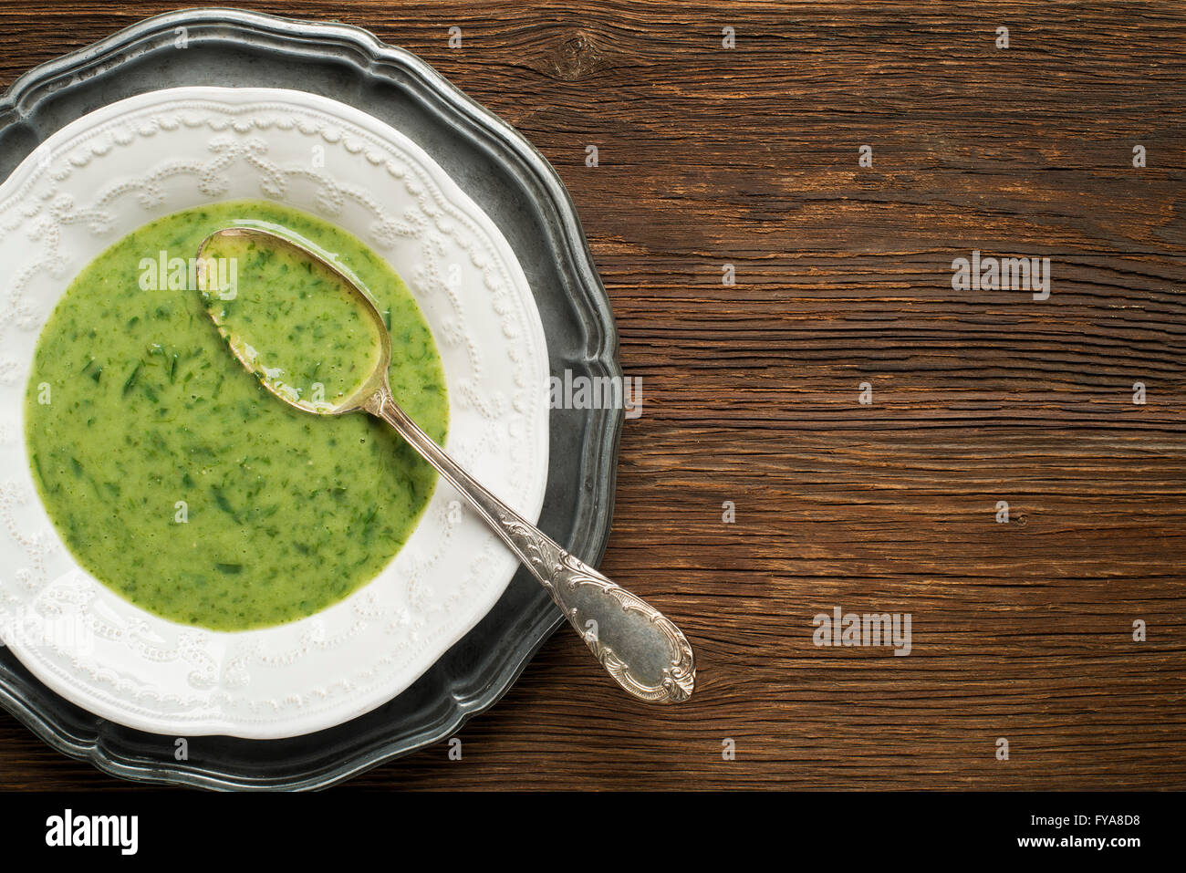 Frische grüne Suppe auf hölzernen Hintergrund Overhead schießen. Stockfoto