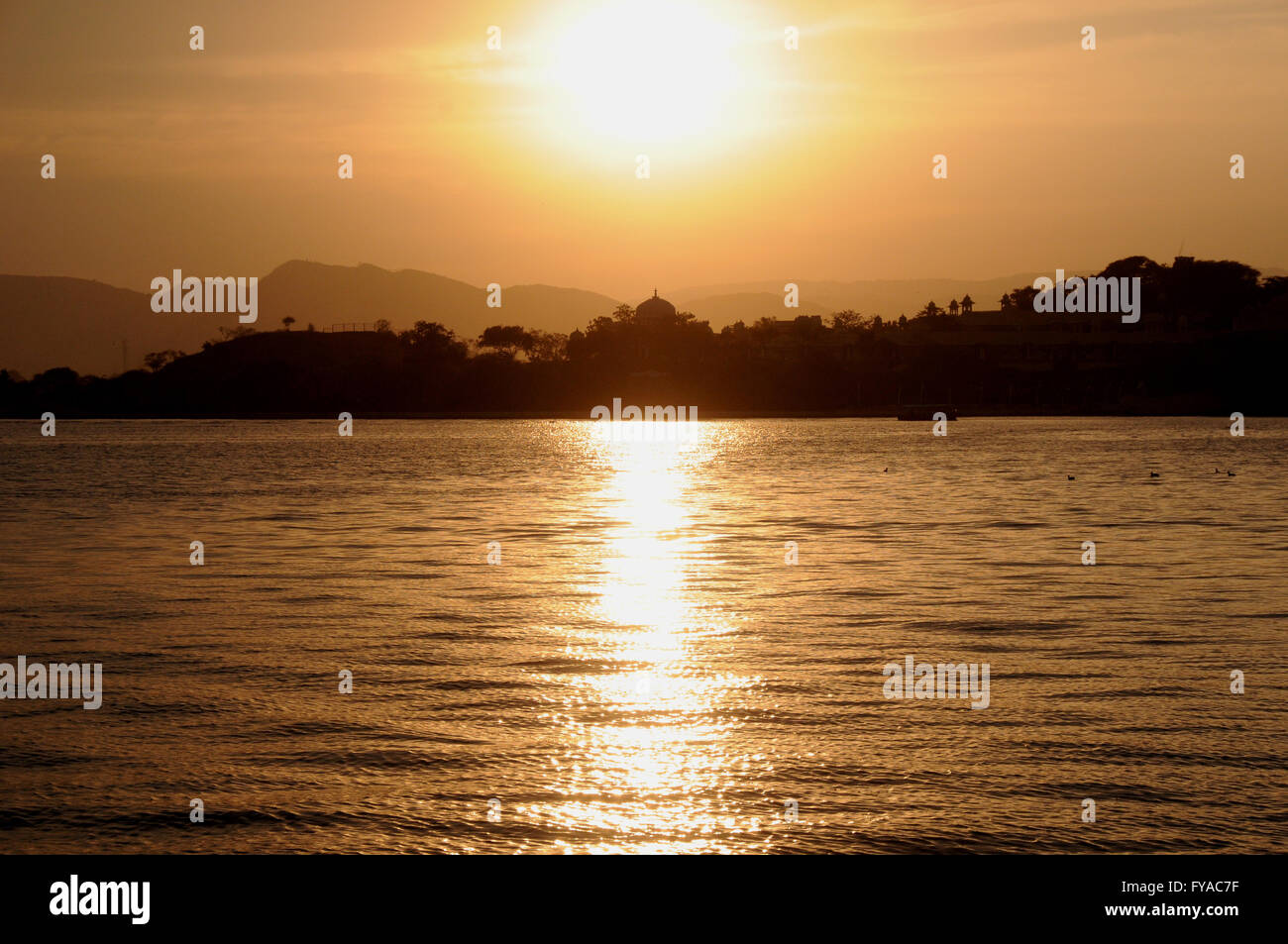 Sonnenuntergang am Pichola-See auf dem steht der Stadt von Udaipur, Rajasthan, Nordindien. Stockfoto