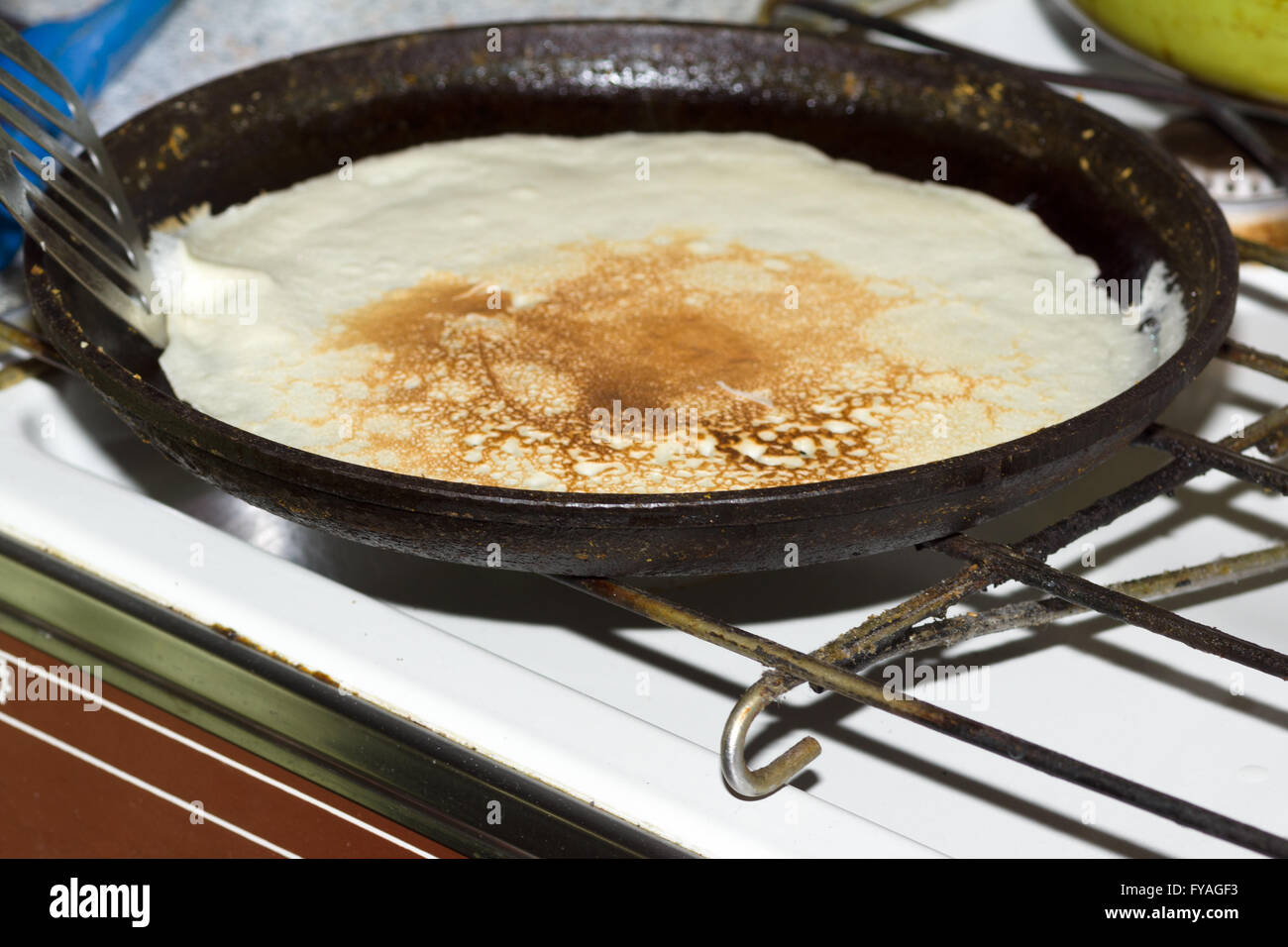 auf einer schwarzen gusseisernen Pfanne Pfannkuchen kochen Mehl Stockfoto