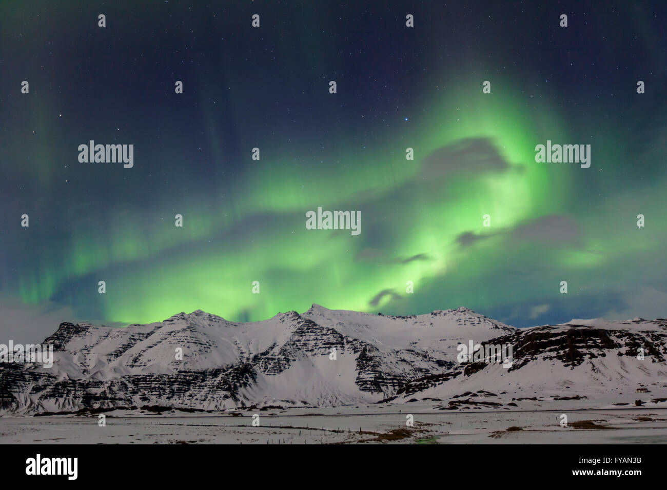 Northern Lights / Aurora Borealis, Wetterphänomen zeigen Licht-Display über den Schnee bedeckt die Berge im Winter, Island Stockfoto