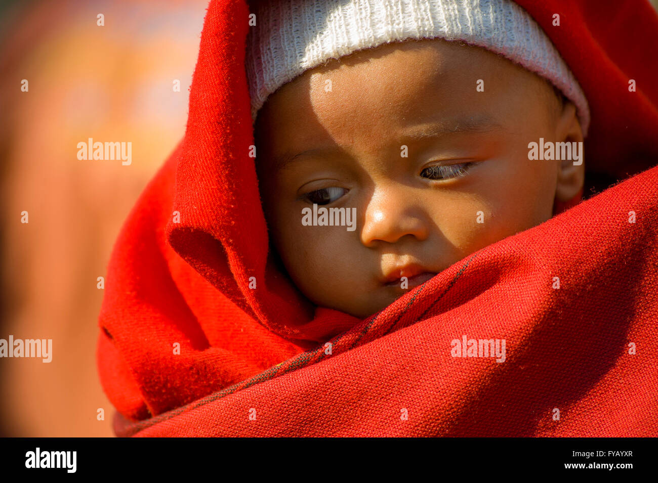 Portrait eines nepalesischen Babyjungen in einem scarlet rote Decke gehalten Stockfoto