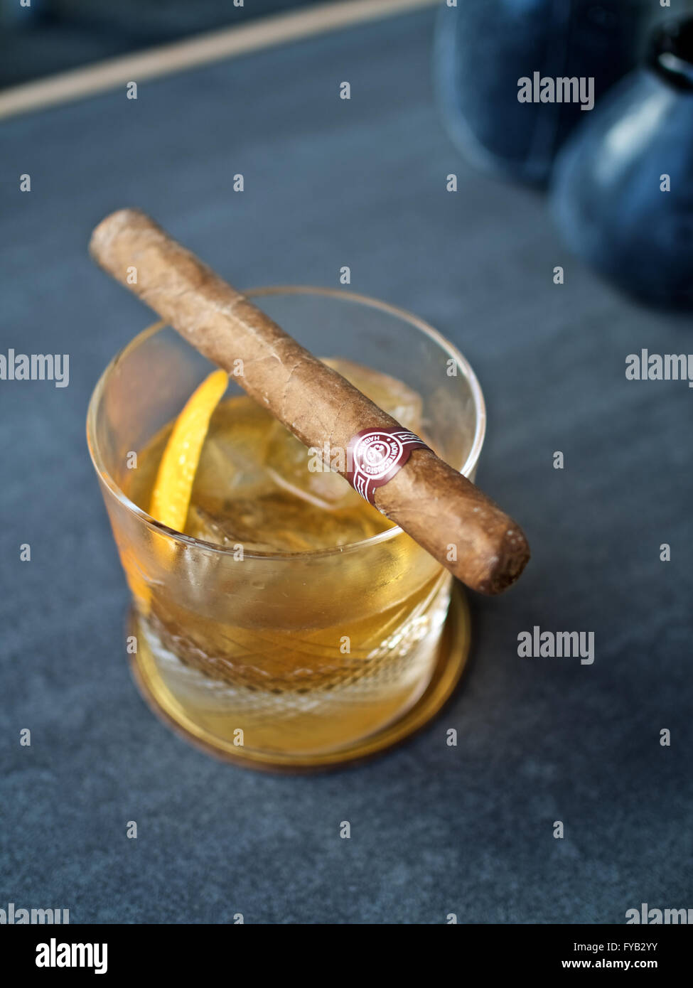Whisky Tumbler Kristall alte altmodische Eisfelsen Leder Untersetzer klassische cocktail trinken Orangenschale garnieren Montecristo No. 3 cub Stockfoto