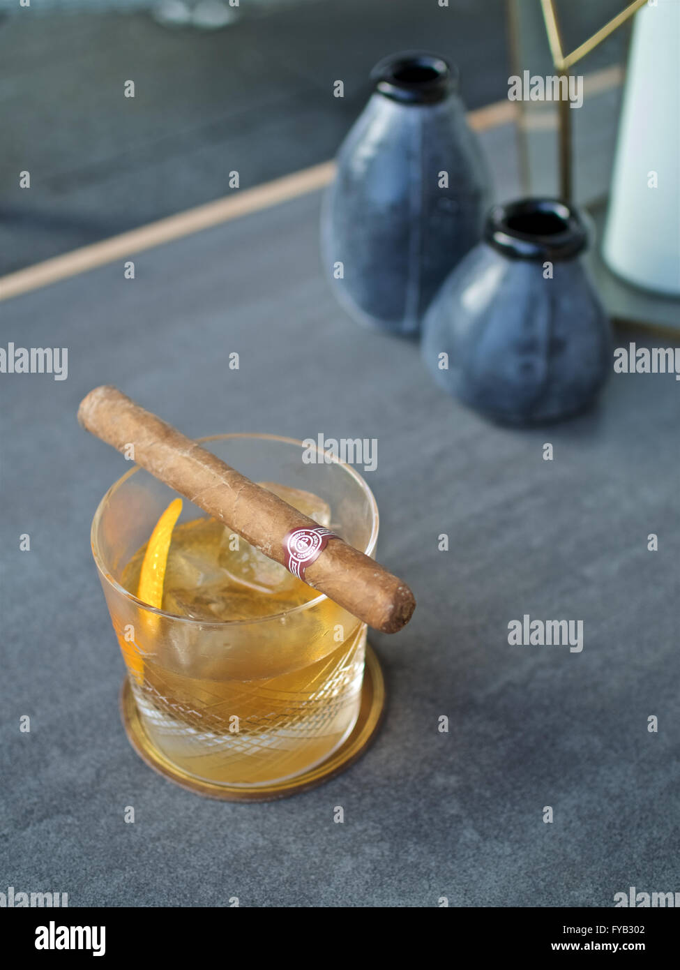 Whisky Tumbler Kristall alte altmodische Eisfelsen Leder Untersetzer klassische cocktail trinken Orangenschale garnieren Montecristo No. 3 cub Stockfoto
