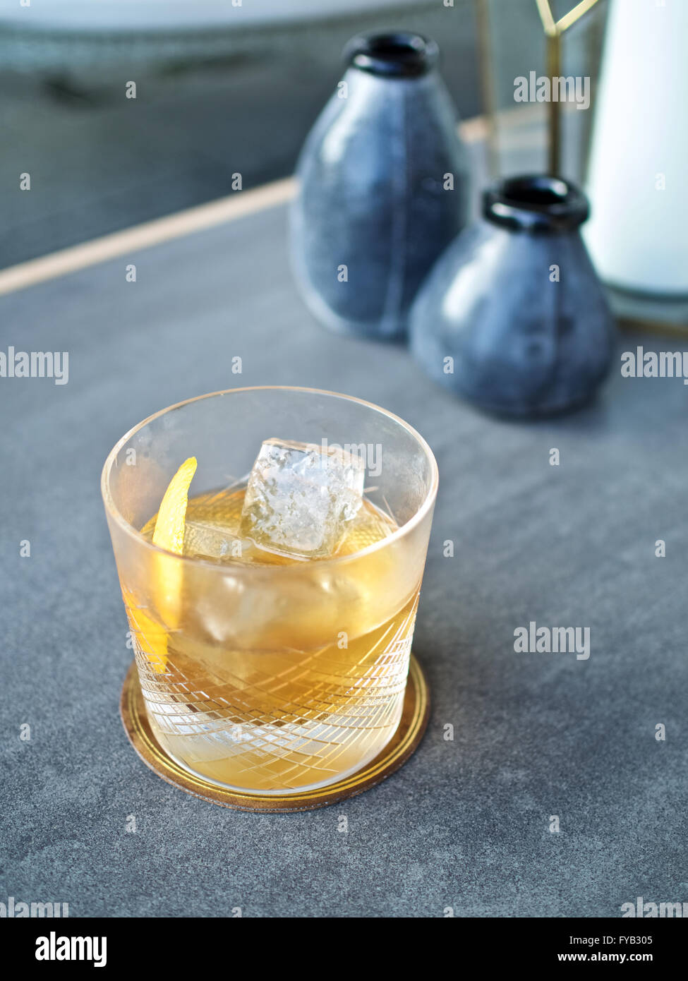 Whisky Tumbler Kristall alte altmodische Eisfelsen Leder Untersetzer cocktail Klassiker Orangenschale garnieren Stockfoto