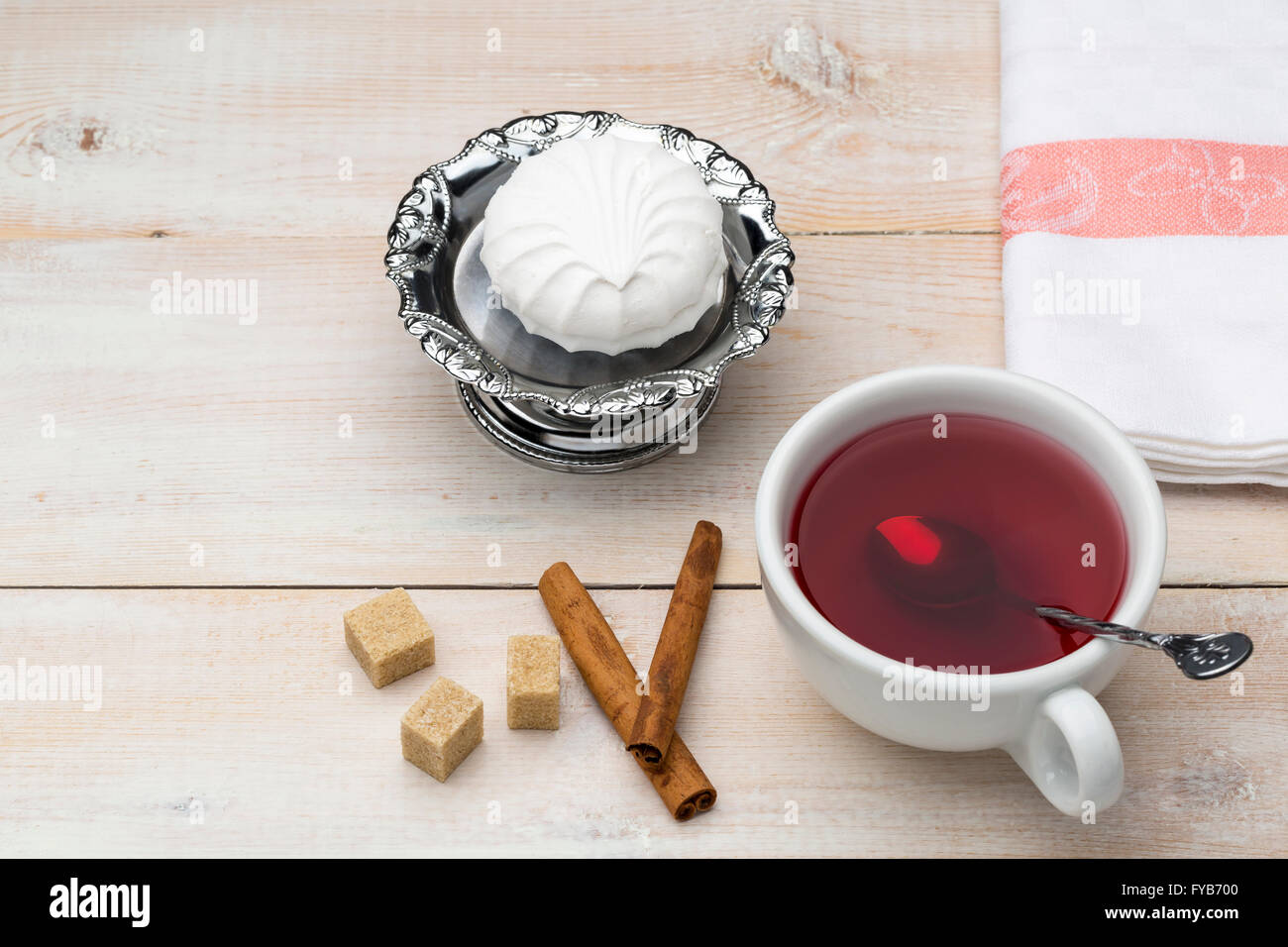 Roter Tee Tasse. Rohrzucker und Zimt-sticks mit süßes Dessert auf Holztisch Stockfoto