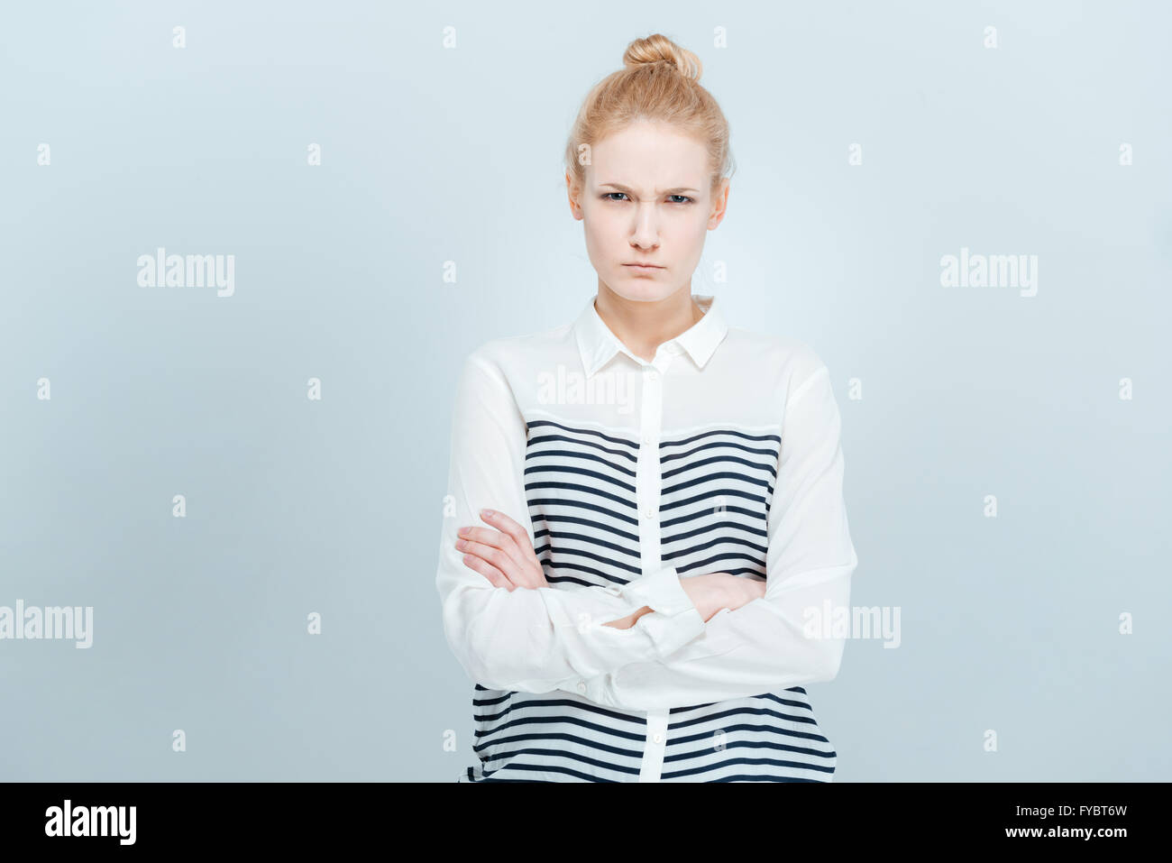 Böse Frau mit Armen gefaltet stehen isoliert auf einem weißen Mentorprogramm Stockfoto