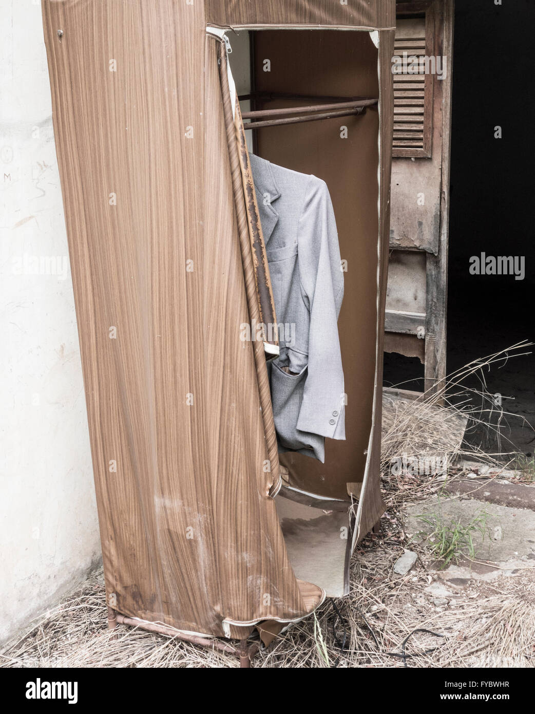 Jacke im Kleiderschrank außerhalb verfallenes Haus hängen. Stockfoto