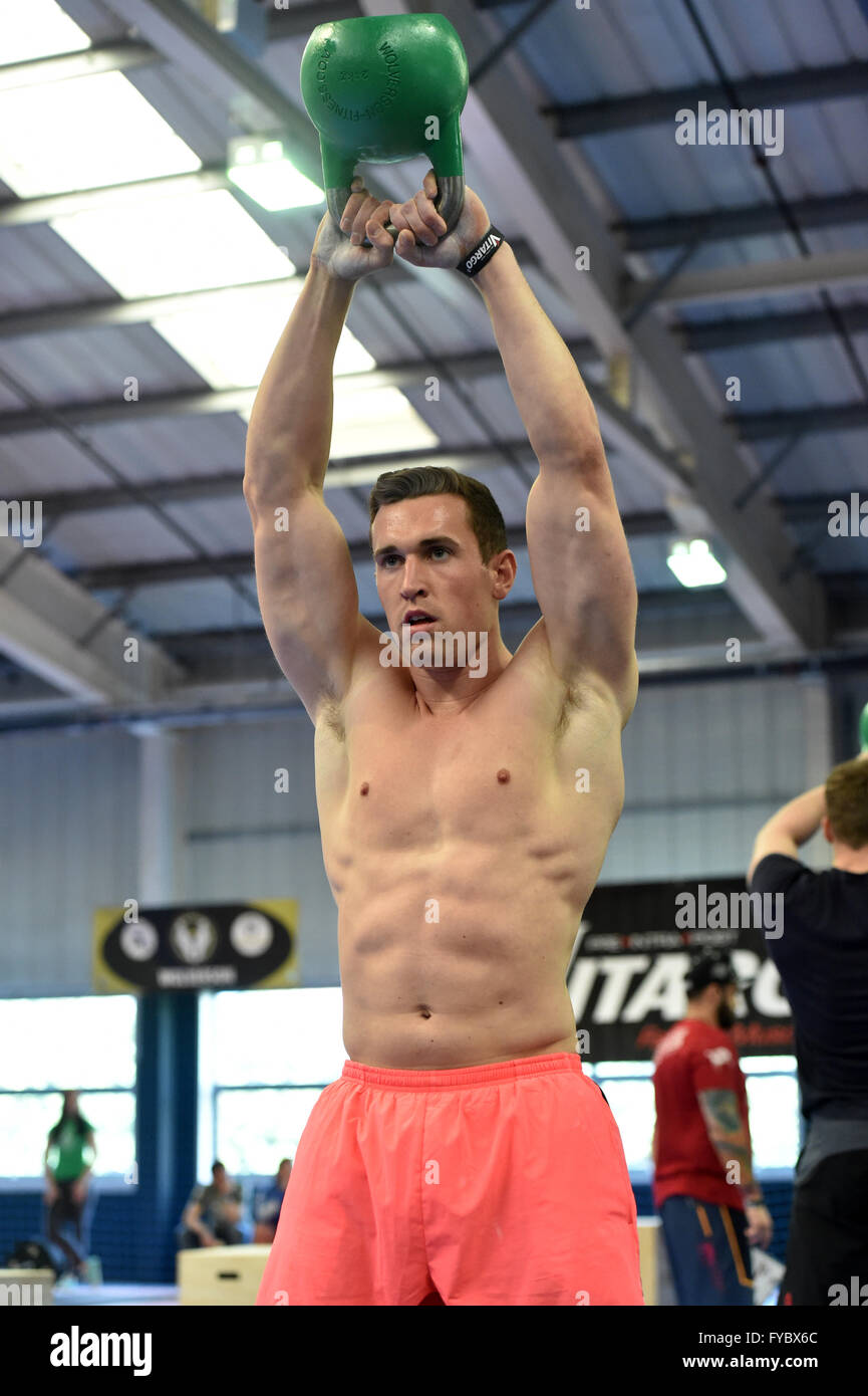 CrossFit Cross Fit männlichen voller Länge in Competiton rosa shorts Muskeln, nackte Brust Gewichte Kugel Wasserkocher springen, überspringen Stockfoto