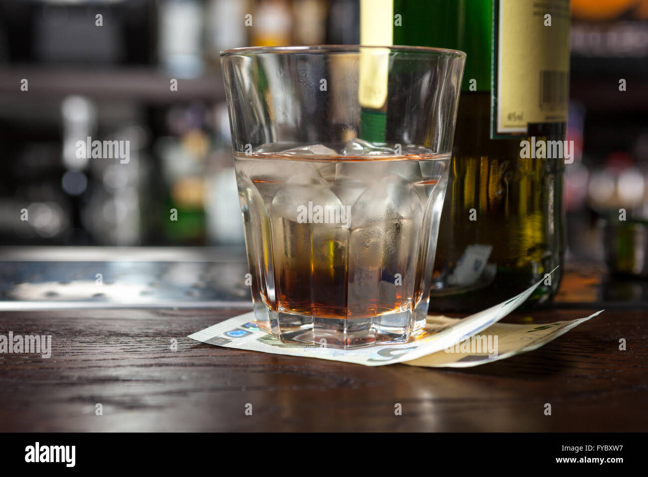 Whiskeyglas mit Alkohol und Tipps auf der Leiste. Stockfoto