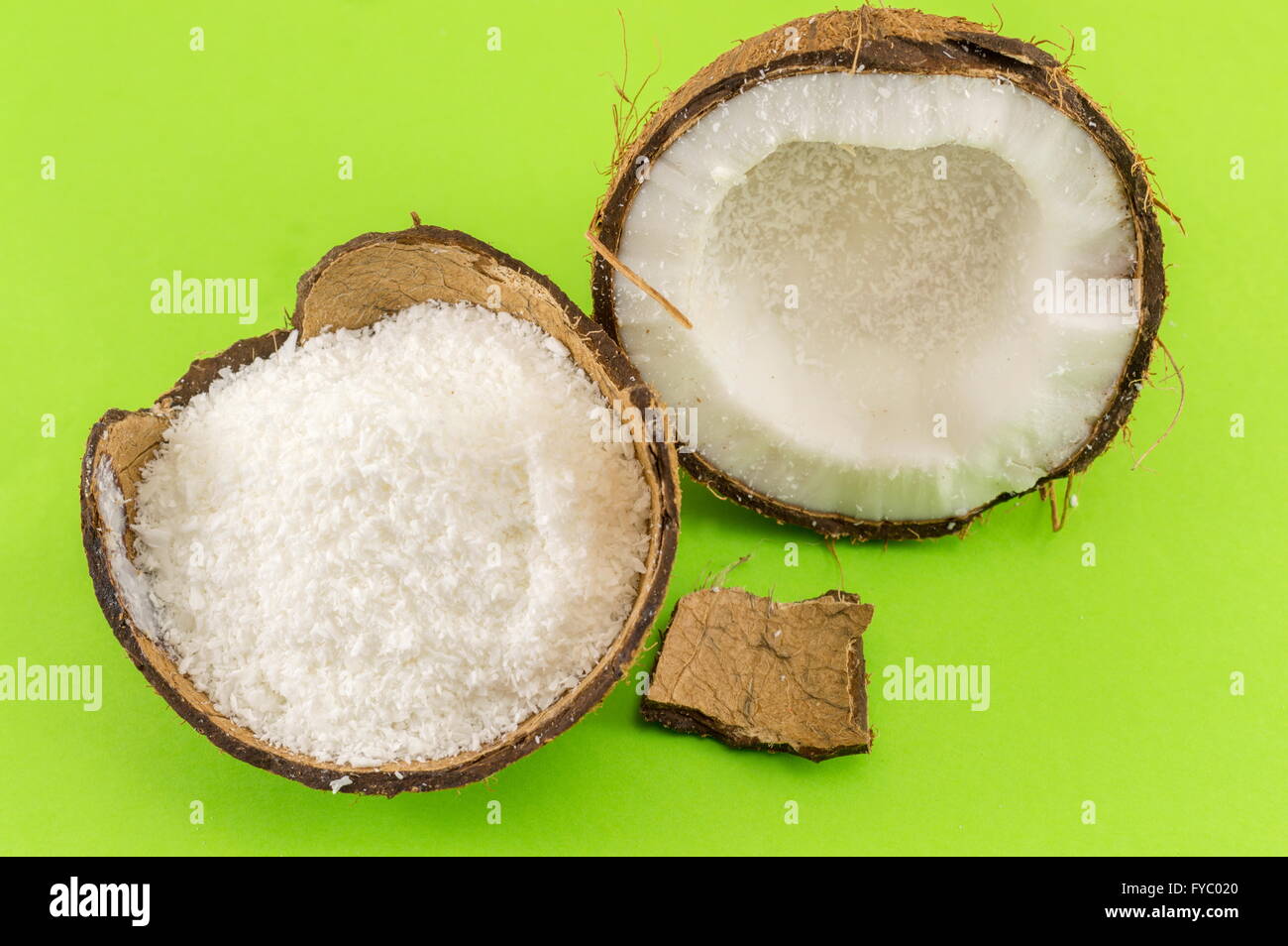 Kokos Pulver in Kokosnussschalen und frische Kokosnuss auf grünem Hintergrund Stockfoto