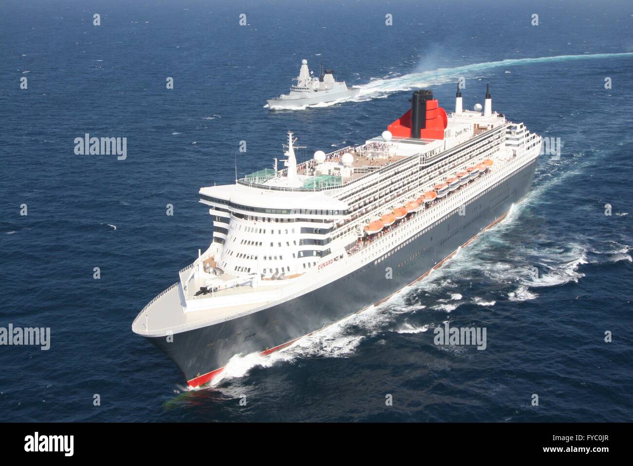 Die königliche Marine Kriegsschiff HMS Defender Praktiken Escort Sicherheit mit Cunard Liner Queen Mary 2 bei International Mine Gegenmaßnahmen Übungen 17. April 2016 in den Golf von Oman. IMCMEX umfasst marinen aus 44 Ländern, deren Schwerpunkt ist die Förderung regionalen Sicherheit durch meinen Gegenmaßnahme Operationen. Stockfoto