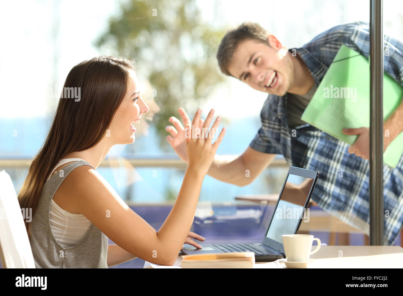 Glückliche Freunde oder paar Gruß winken Hände und suchen einander in einem Datum in einem Coffee-shop Stockfoto