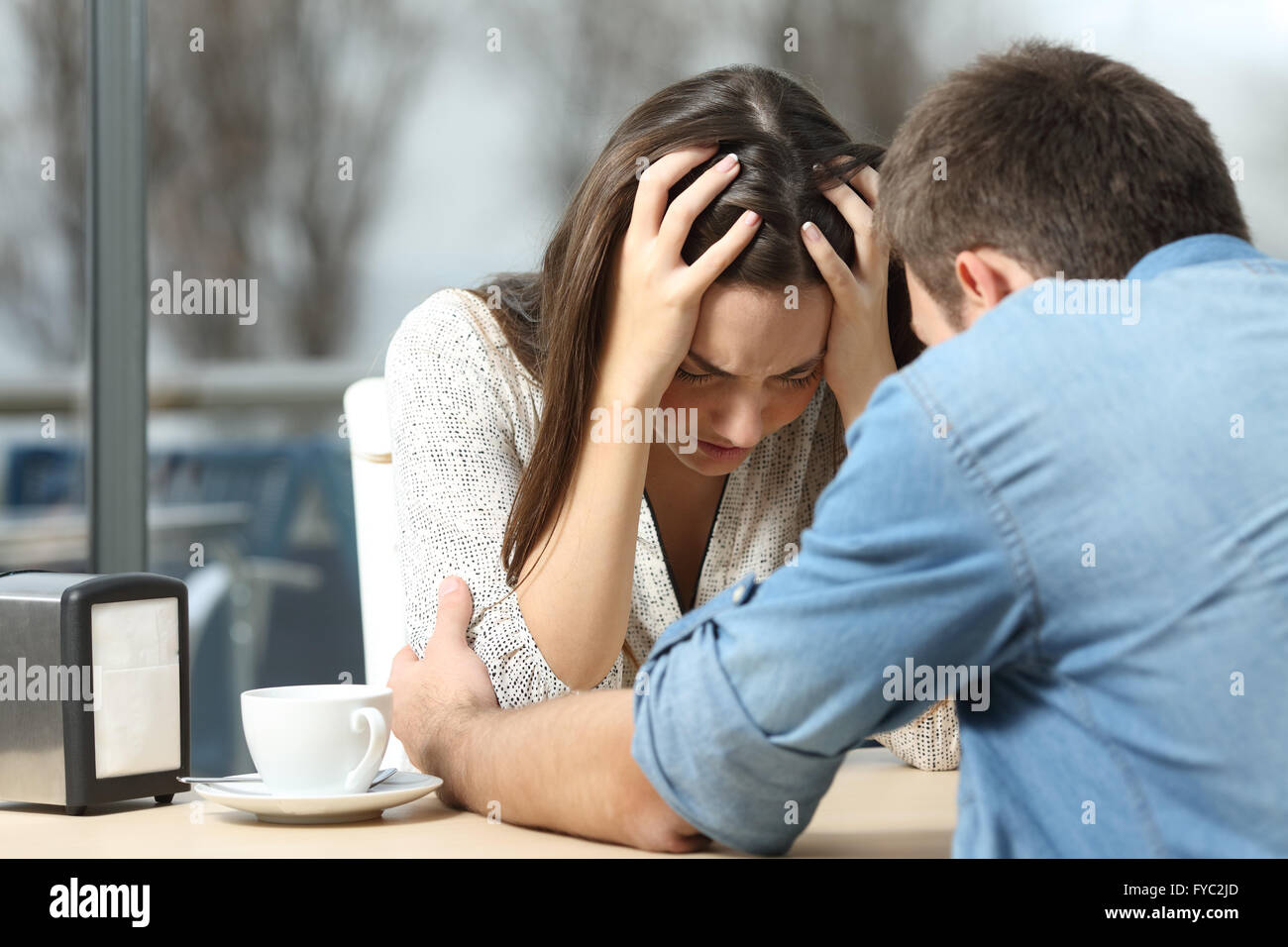 Männliche beruhigend zu einem traurigen deprimiert weiblich wer Hilfe in einem Café braucht. Zerbrechen oder bester Freund Konzept Stockfoto