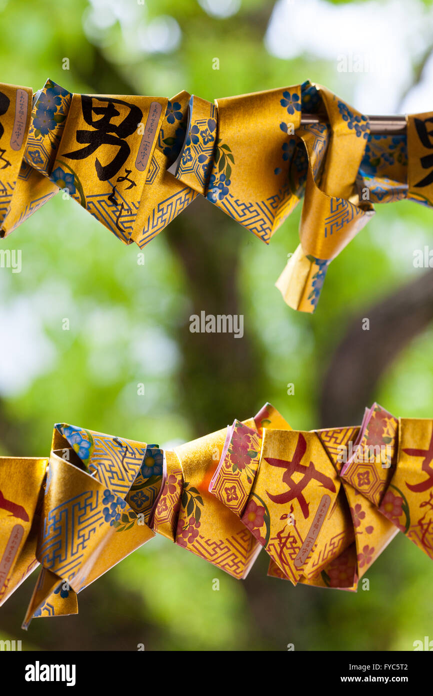 Close up of gold paper Omikuji tied at a Shrine in Japan Stockfoto